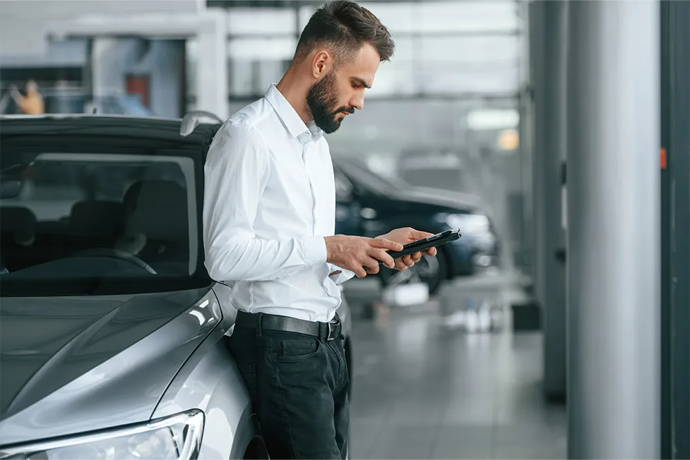 Client într-un showroom partener Moov, configurând pe telefon mașina și rata lunară